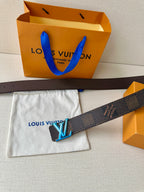 Louis Vuitton belt across white pouch, dark monogram with blue LV buckle