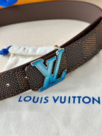 Louis Vuitton belt detail: dark monogram strap with blue LV buckle