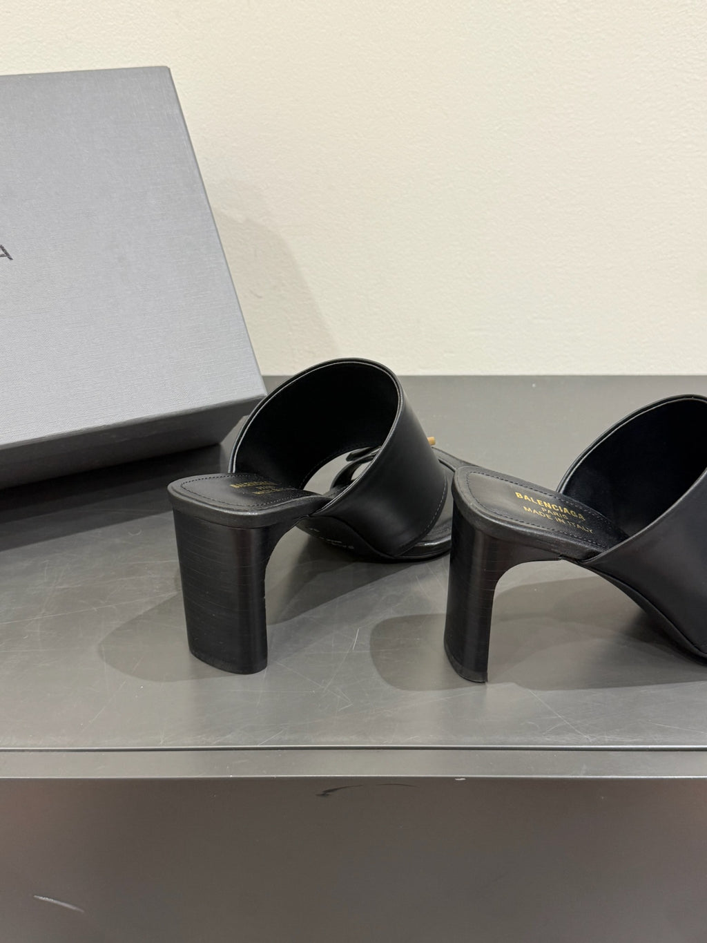 Black leather mule sandals with gold buckle, black block heel, pair on display