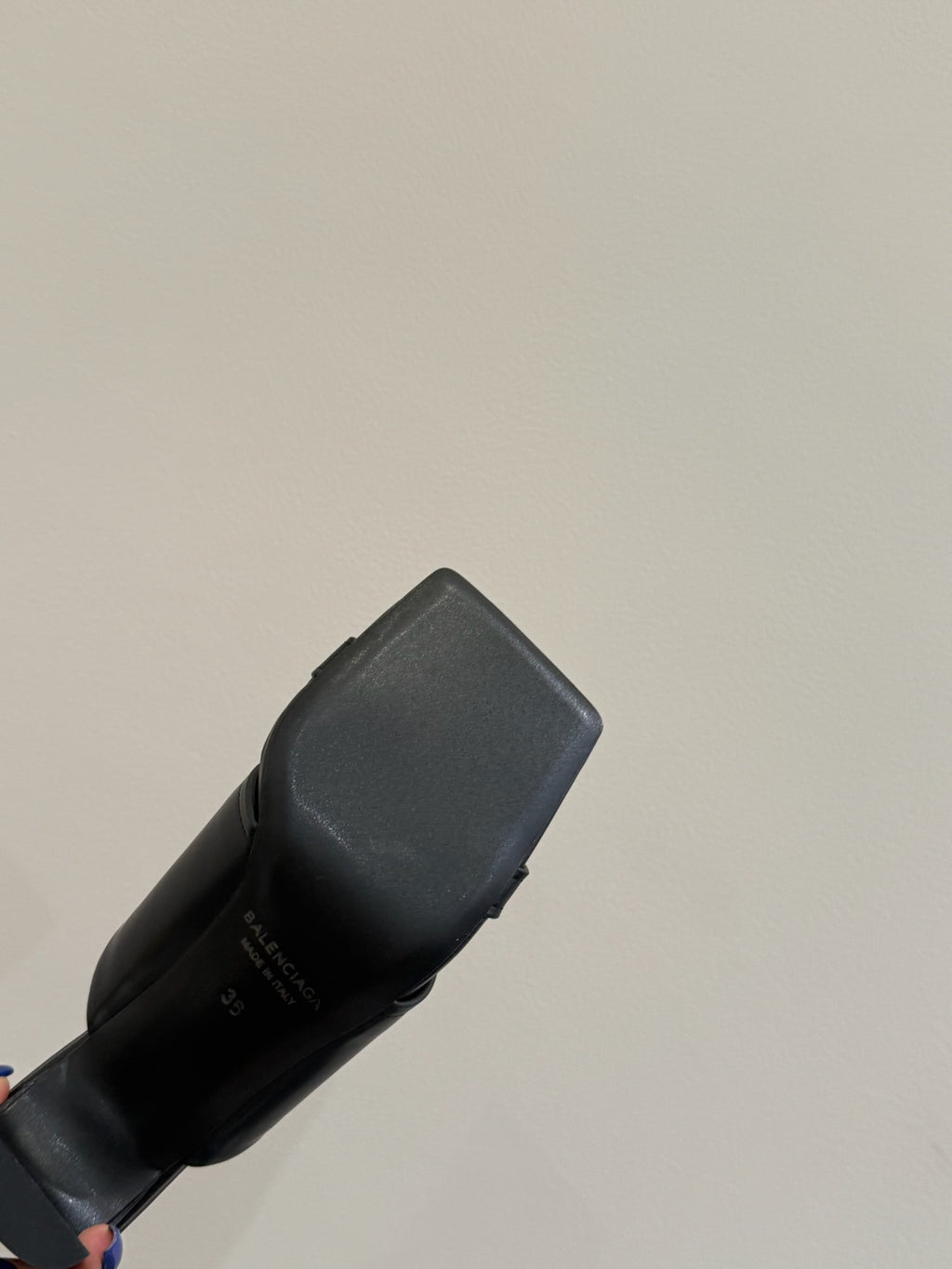 Black leather slide sandal, close-up of back heel and strap