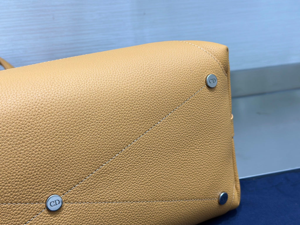 Tan leather side panel with small CD logo stud hardware