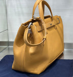 Tan leather tote bag with short handles and adjustable shoulder strap