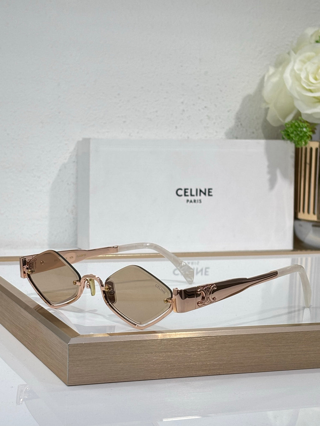 Celine eyeglasses with rose-tinted clear lenses, gold-tone metal frame, slim temples.