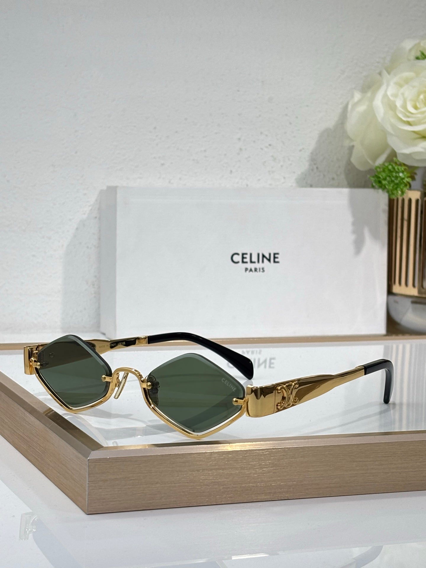 Celine eyeglasses with gold-tone frame, dark green lenses, curved metal temple detail.