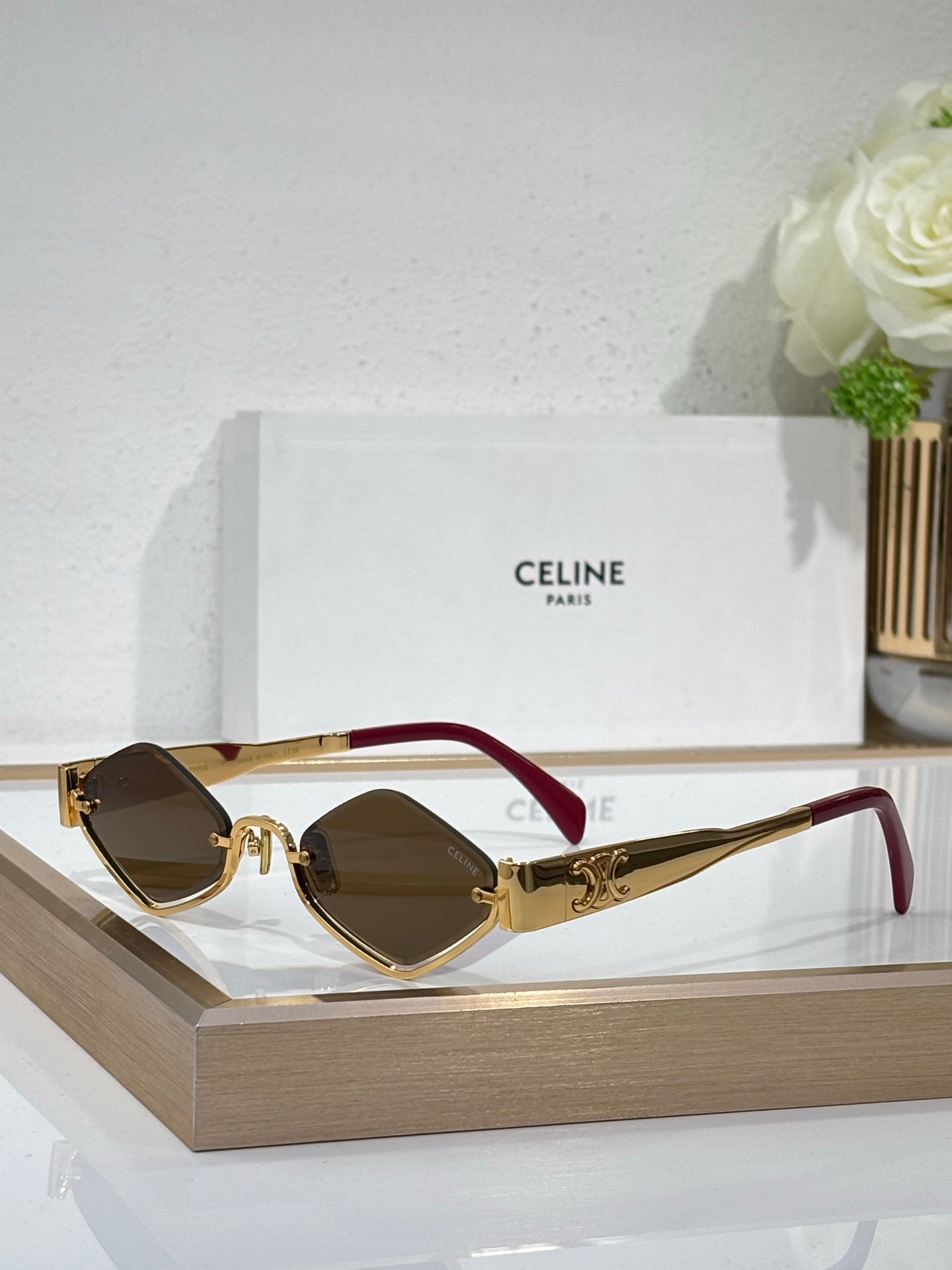 Celine eyeglasses with dark lenses, gold-tone frame and burgundy temple accents.
