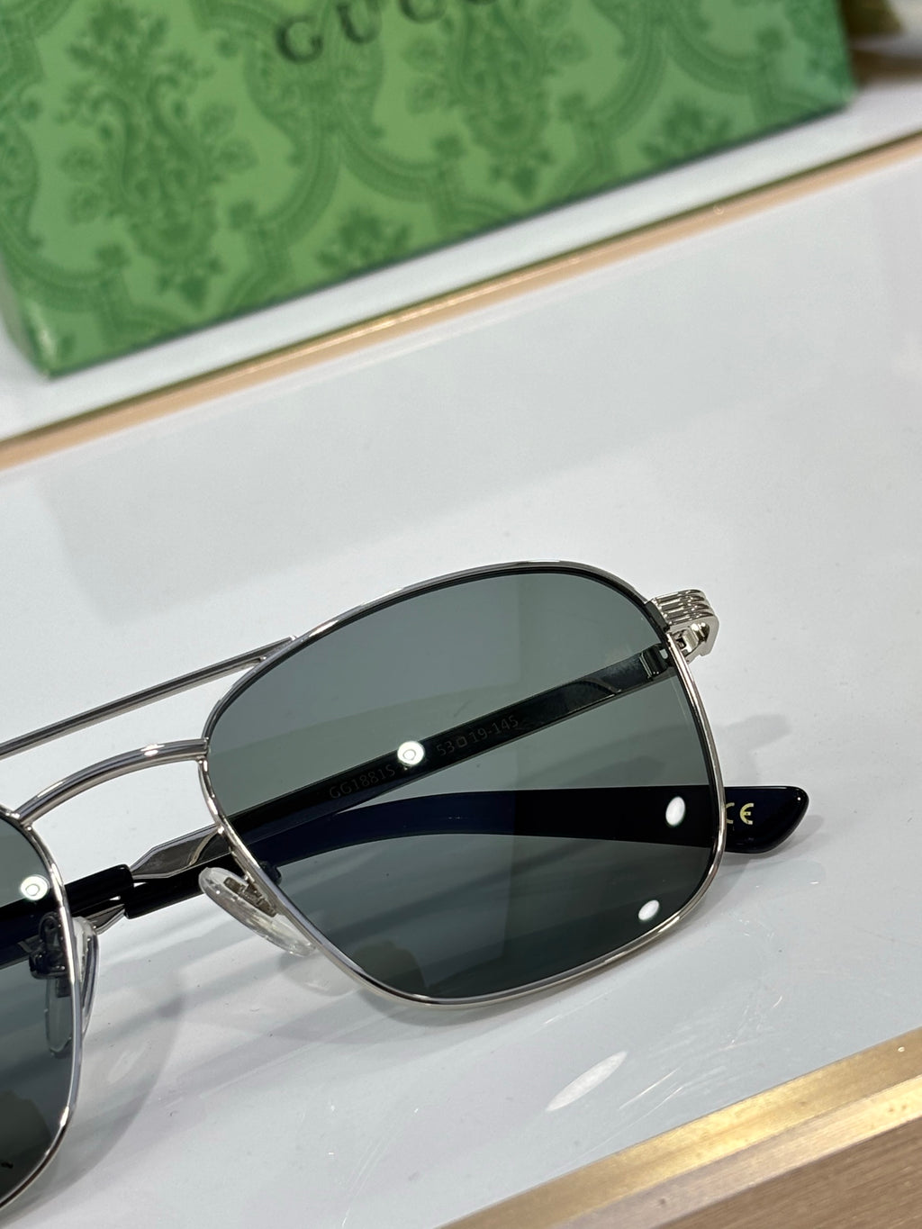 Gucci sunglasses close-up with dark lenses and silver-tone metal frame