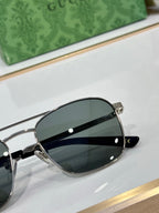 Gucci sunglasses close-up with dark lenses and silver-tone metal frame