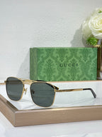 Gucci sunglasses with dark gray lenses and gold-tone metal frame