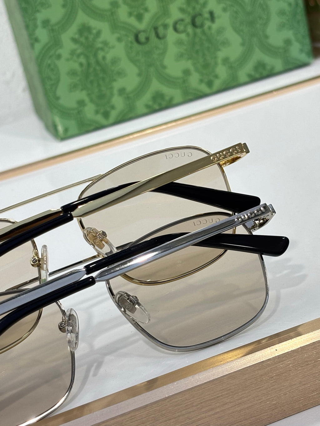 Gucci sunglasses close-up with black and gold frames and mirrored lenses