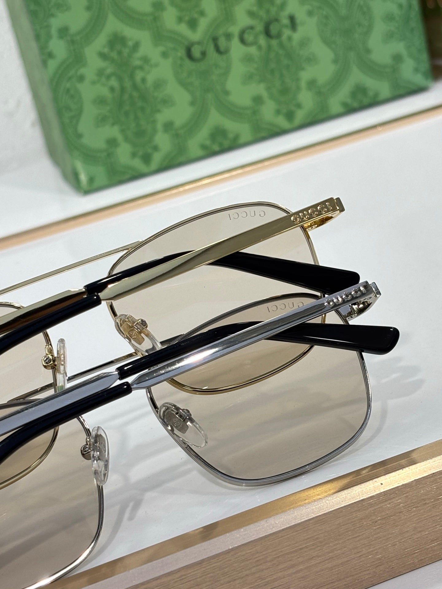 Gucci sunglasses close-up with black and gold frames and mirrored lenses
