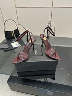 Pair of burgundy pointed-toe strappy sandals with thin stiletto heels and ring straps