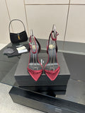 Pink stiletto heeled sandals with black straps and silver wire arch detail