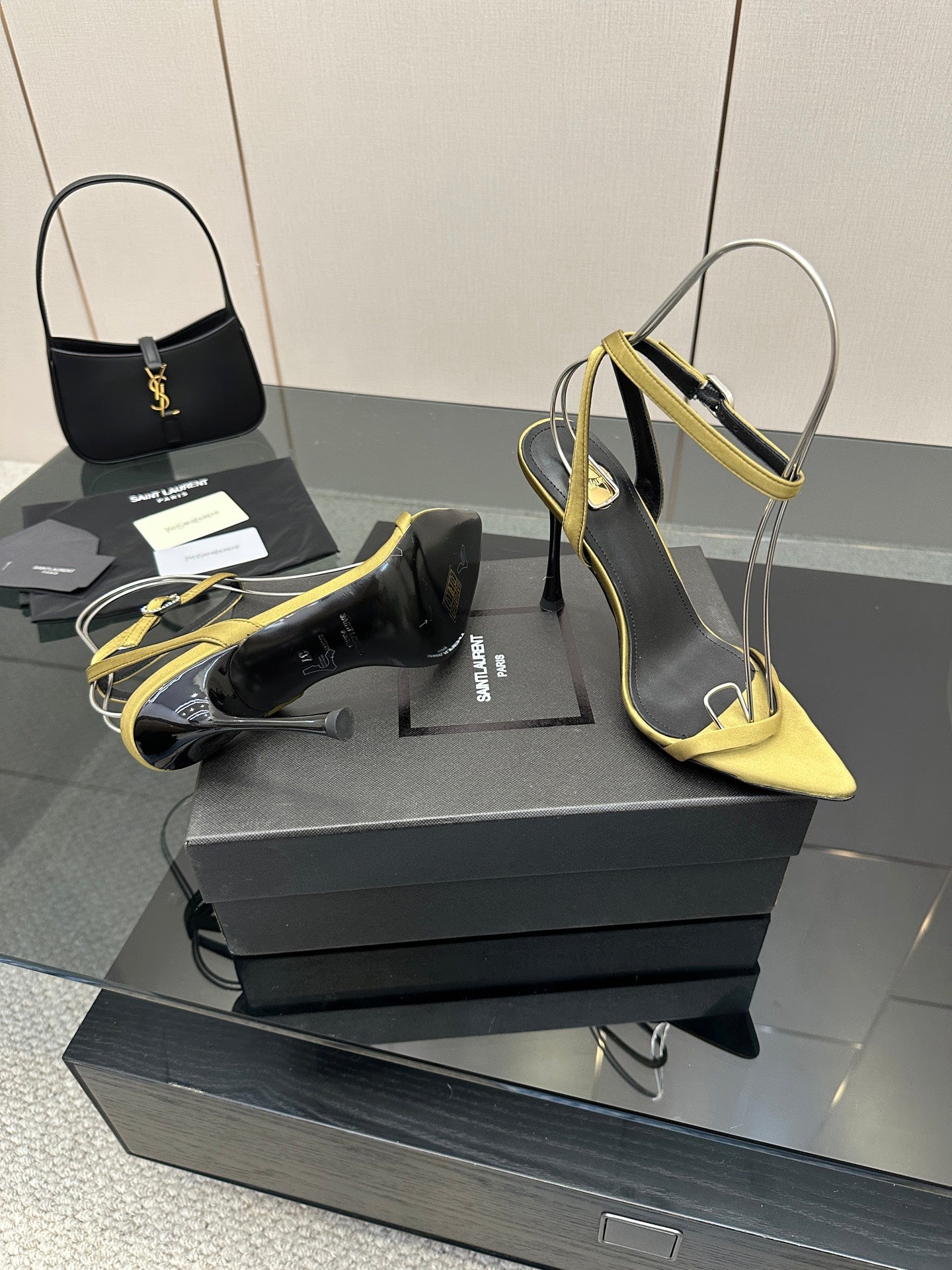 Women’s two-tone heeled sandals: black upper with yellow straps and pointed toe.