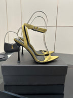 Women’s YSL heeled sandals with yellow strap trim, black upper, pointed toe and stiletto.