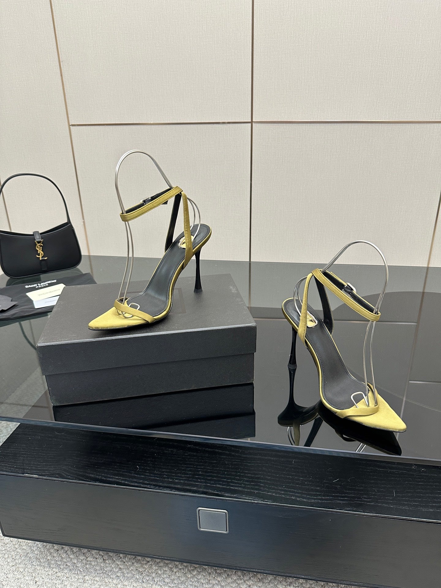 Women’s heeled sandals with yellow pointed toe and strap, black upper, slim stiletto heel.