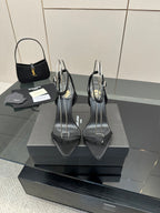 Black women’s high-heel sandals with T-strap and pointed toe, on a display stand