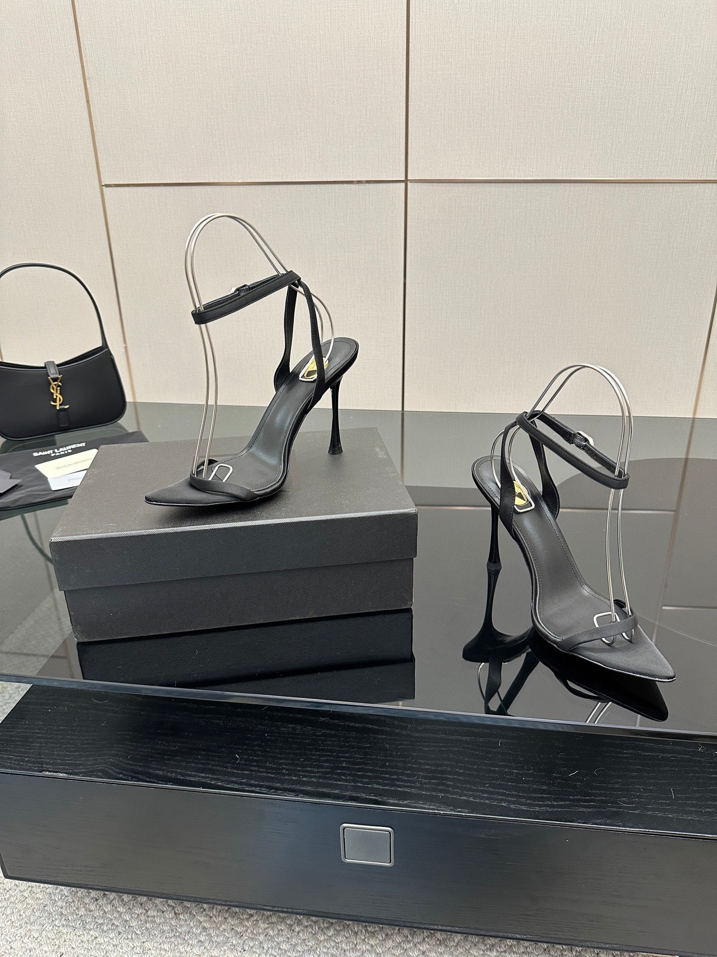 Black women’s high-heel sandals with ankle strap and pointed toe, close angle