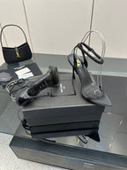 Black women’s high-heel sandals with T-strap and pointed toe, plus matching handbag