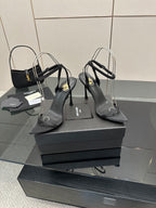 Black women’s high-heel sandals with ankle strap and pointed toe, side view