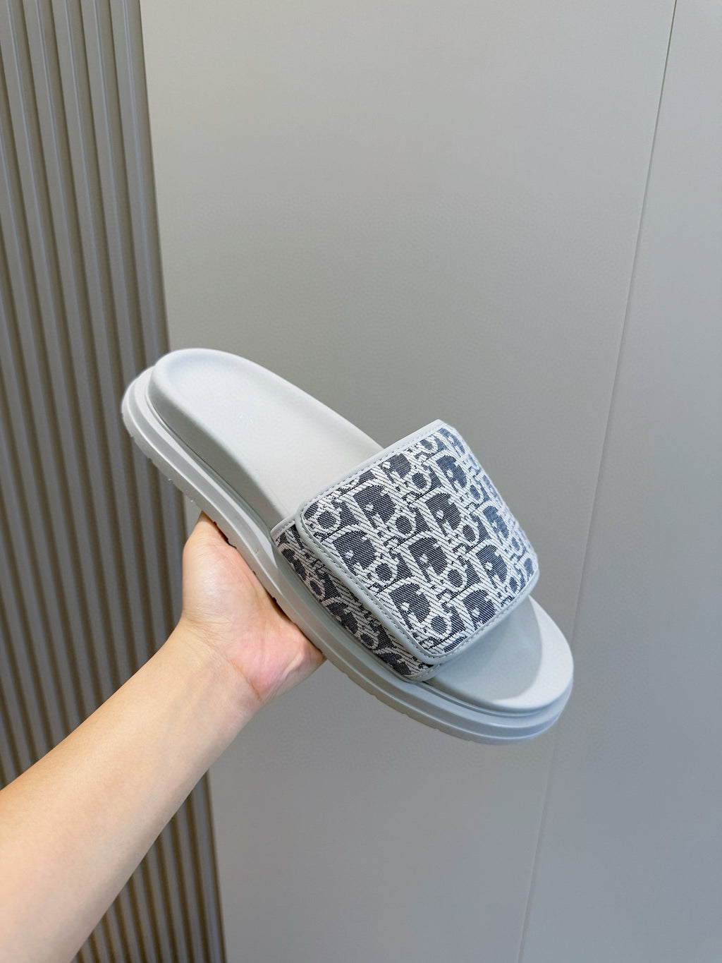 Dior slide sandal held in hand, navy Oblique-print strap with light blue sole