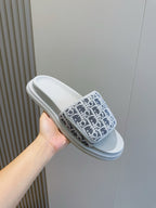 Dior slide sandal held in hand, navy Oblique-print strap with light blue sole