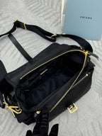 Prada black nylon crossbody bag with long strap, gold zippers, and front buckle