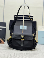 Prada black nylon tote-style bag with top handles, flap front, and gold hardware