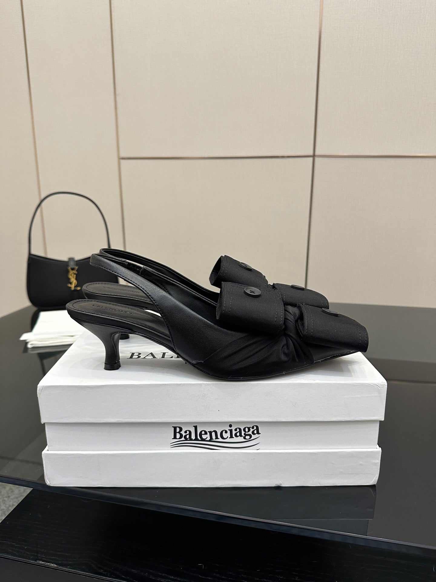 Black mules with low block heel and slingback strap, on stacked boxes