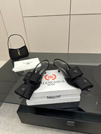 Black strappy mules with buckled straps and low block heel, on stacked boxes