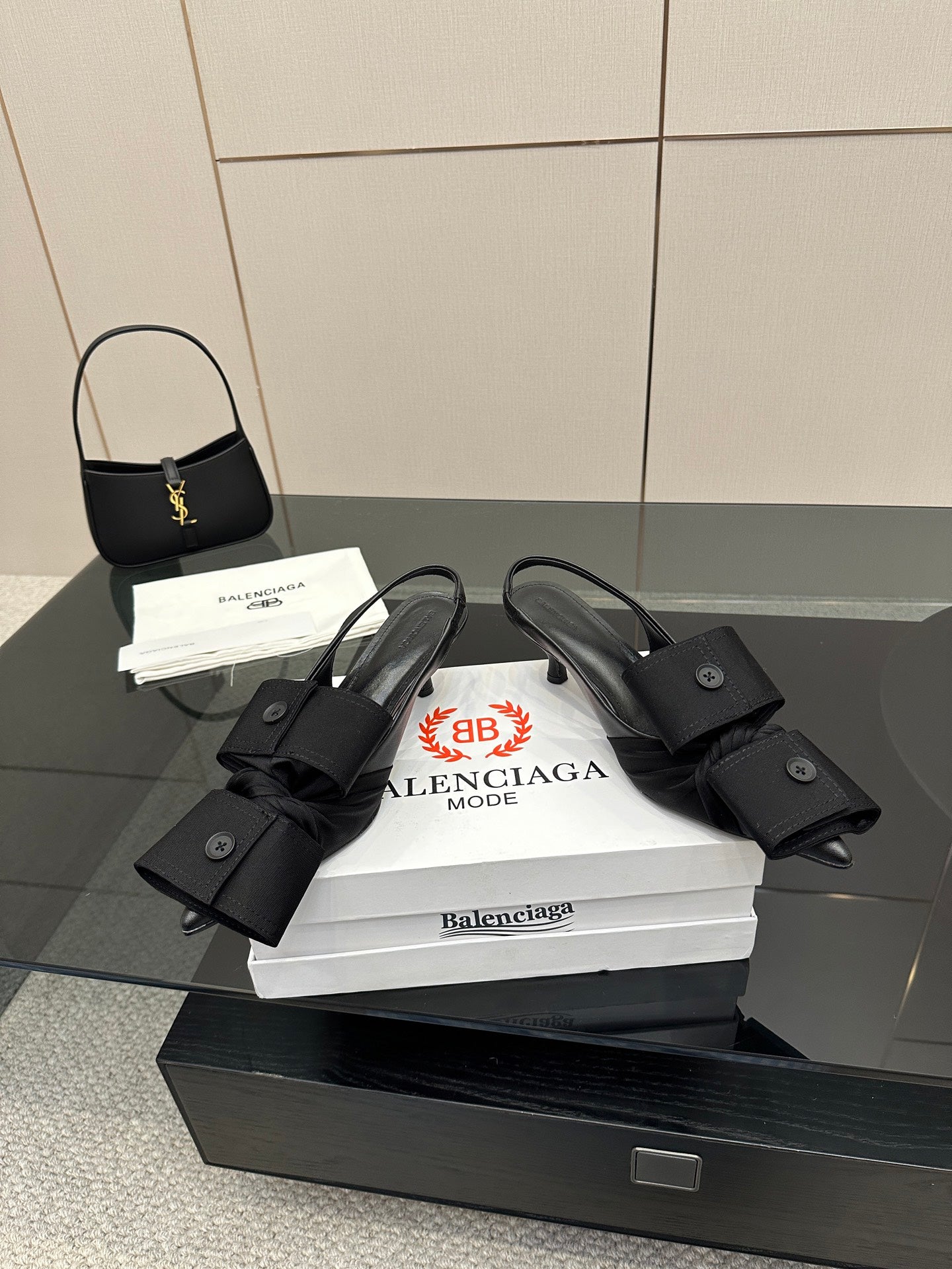 Black strappy mules with buckled straps and low block heel, on stacked boxes