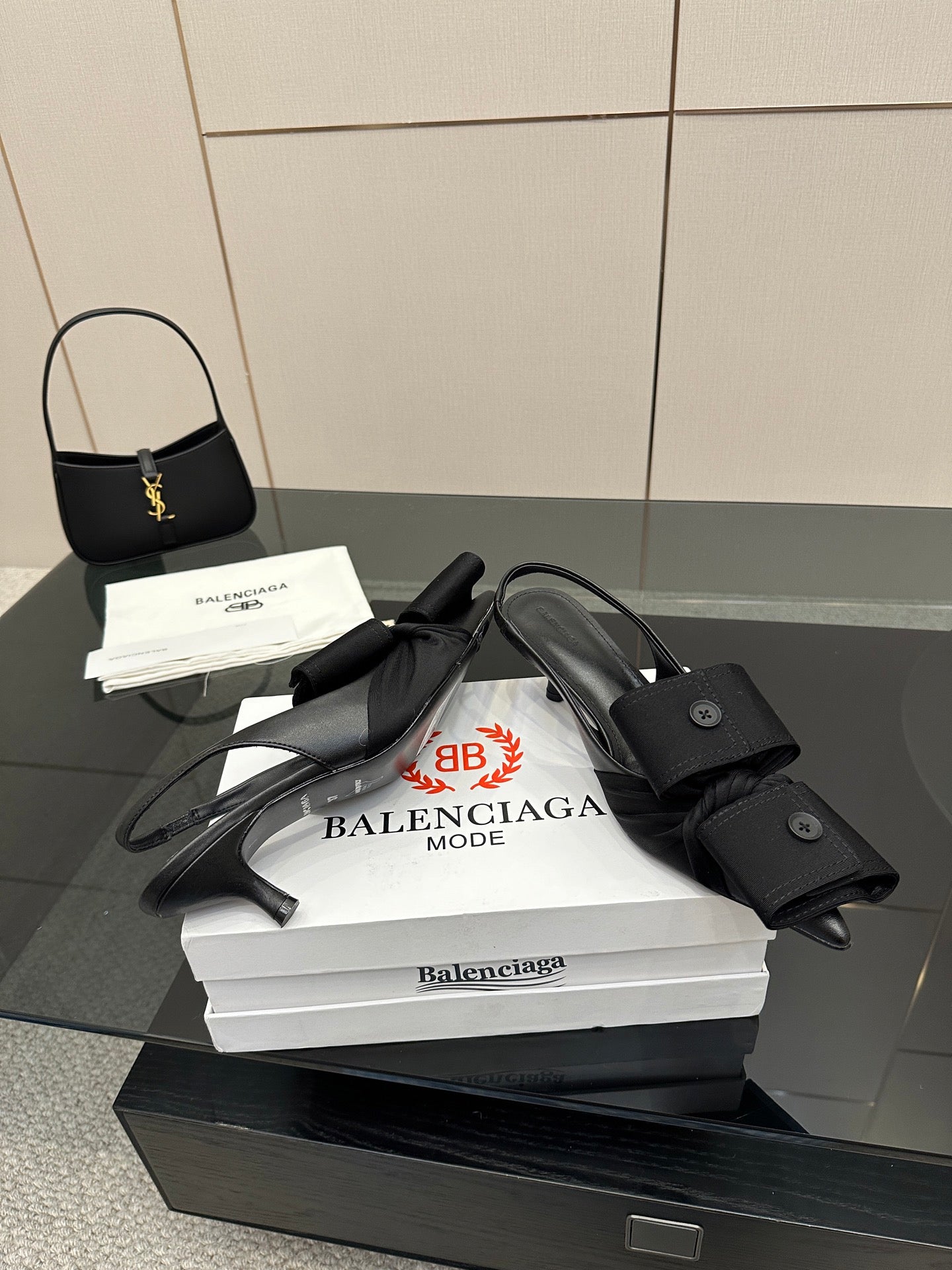 Black mules with toe and ankle straps and low block heel, on stacked boxes