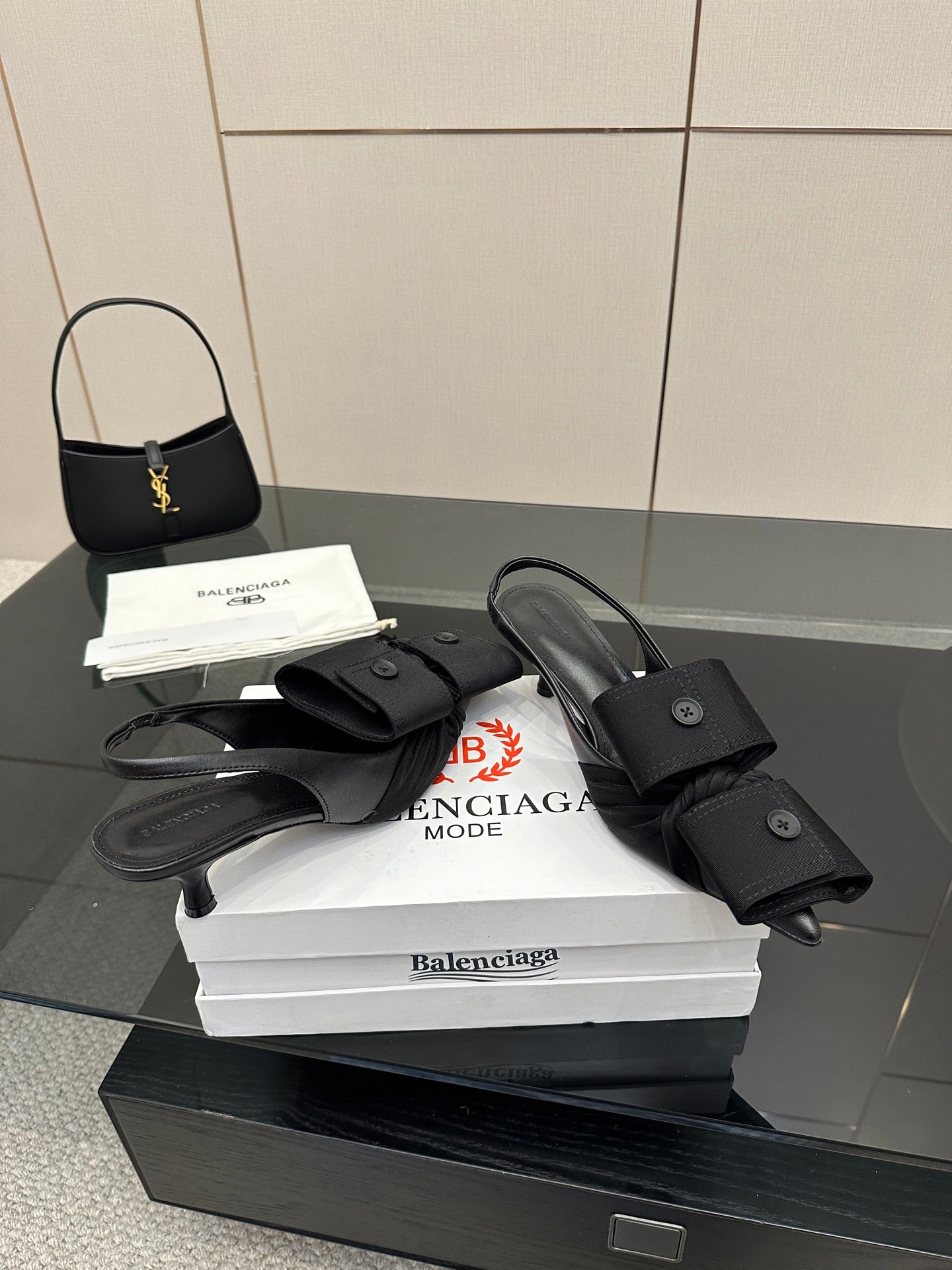 Black mules with buckled straps and low block heel, on white Balenciaga box