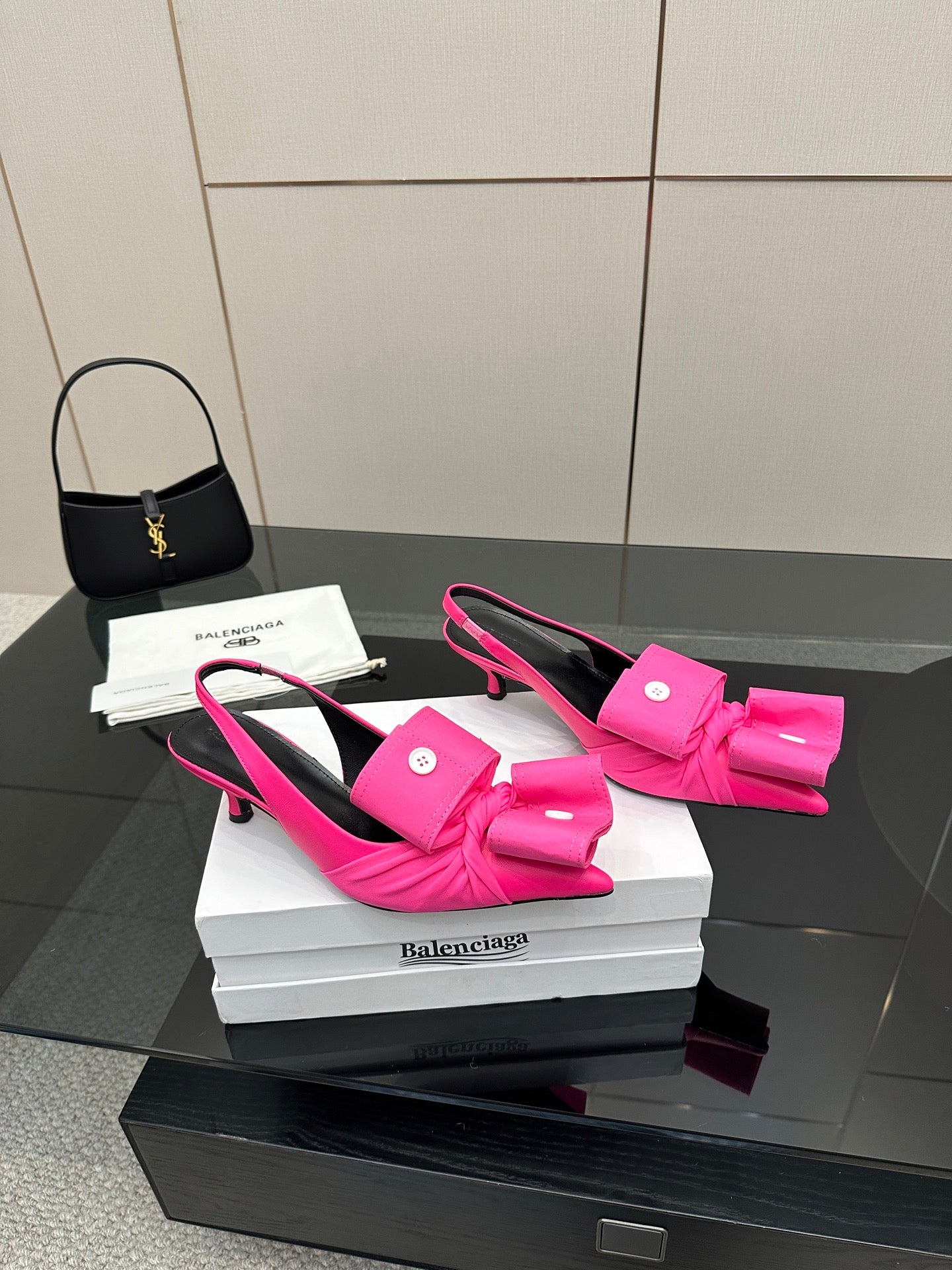 Pink bow mule sandals on white boxes, stiletto heel and sling-back strap visible