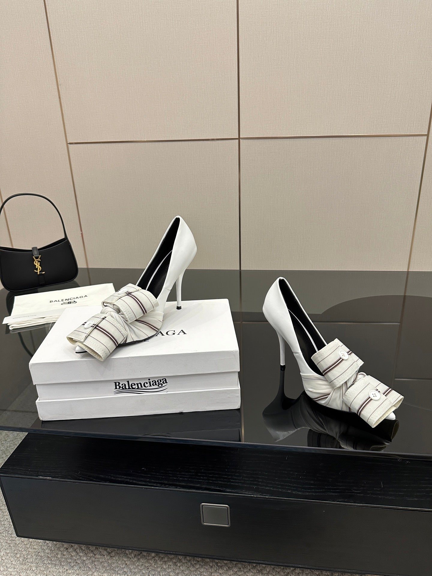 Balenciaga women\u2019s white heeled mules with striped straps and buckle, side-by-side
