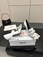 Balenciaga women\u2019s white heeled mules with striped strap and buckle, angled view
