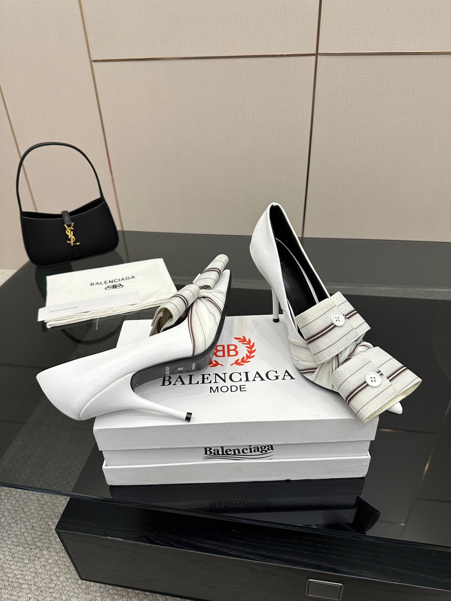 Balenciaga women\u2019s white heeled mules with striped strap and buckle, angled view