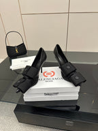 Pair of black pointed-toe high heel slingback shoes with wrapped ankle straps