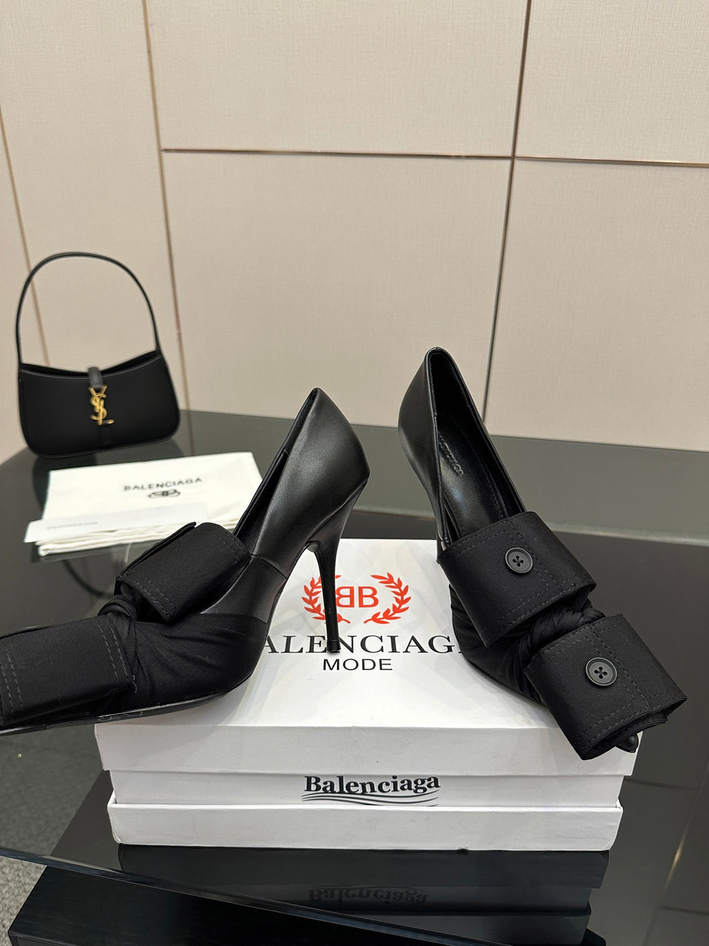Black pointed-toe high heel slingback shoes with ruffled ankle strap and buttons
