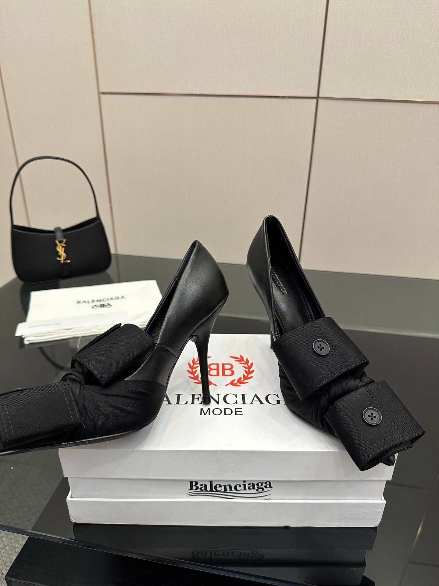 Black pointed-toe high heel slingback shoes with ruffled ankle strap and buttons