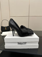 Black pointed-toe high heel slingback shoe with two-button ankle strap