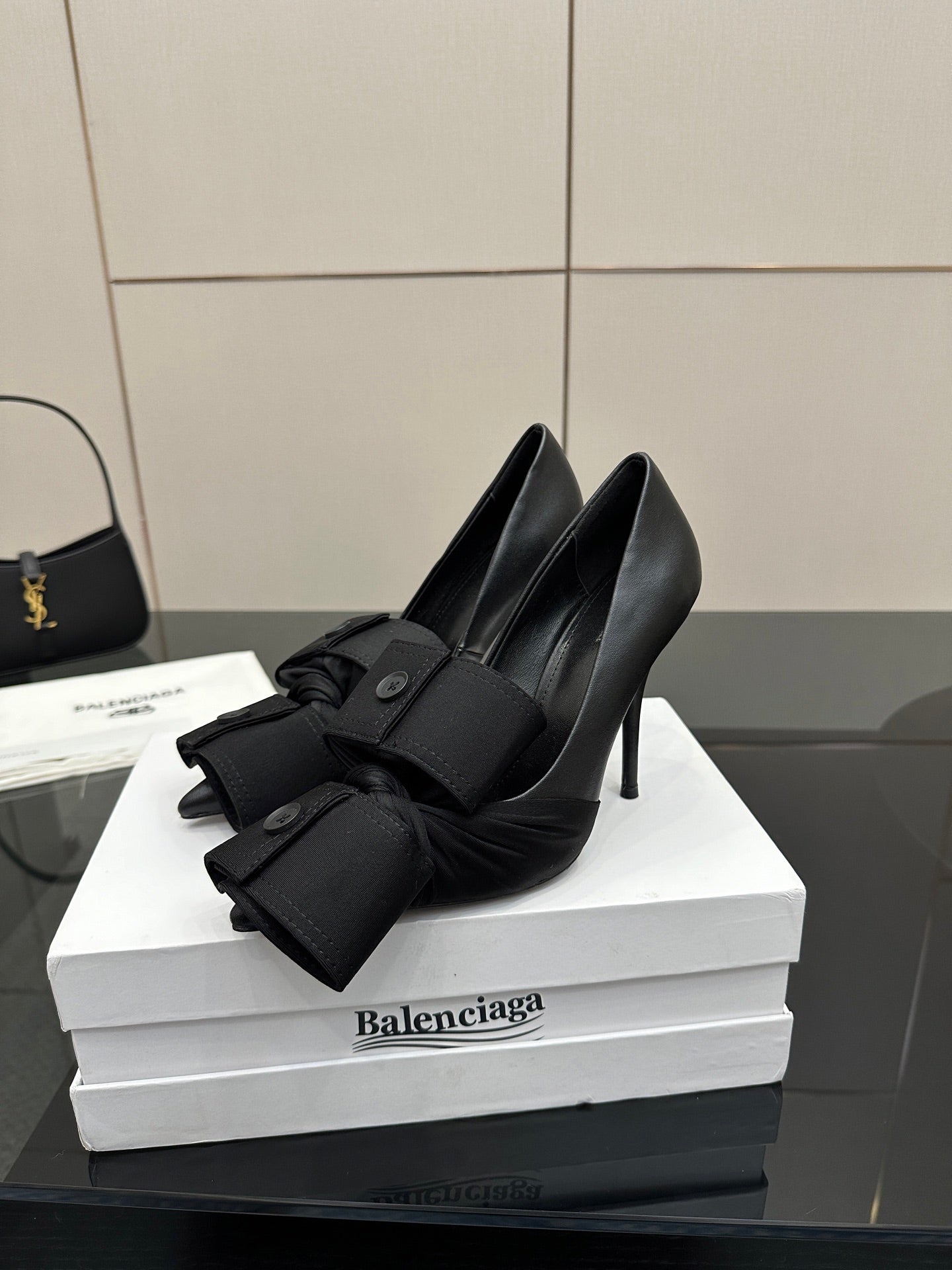 Black pointed-toe high heel slingback shoes with two straps and button accents