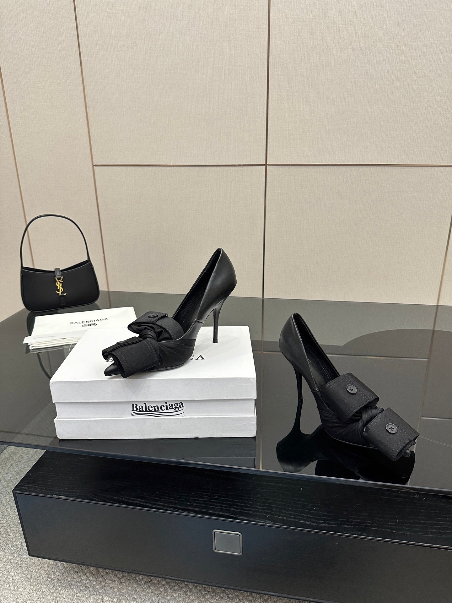 Black pointed-toe high heel slingback shoes with ankle wrap straps and button closures