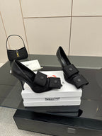 Black pointed-toe high heel slingback shoes with wide ankle strap and button detail