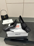 Pair of black pointed-toe high heel slingback shoes on white boxes, strap detail