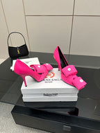 Pink high-heel pumps with bow-tie straps and round button hardware