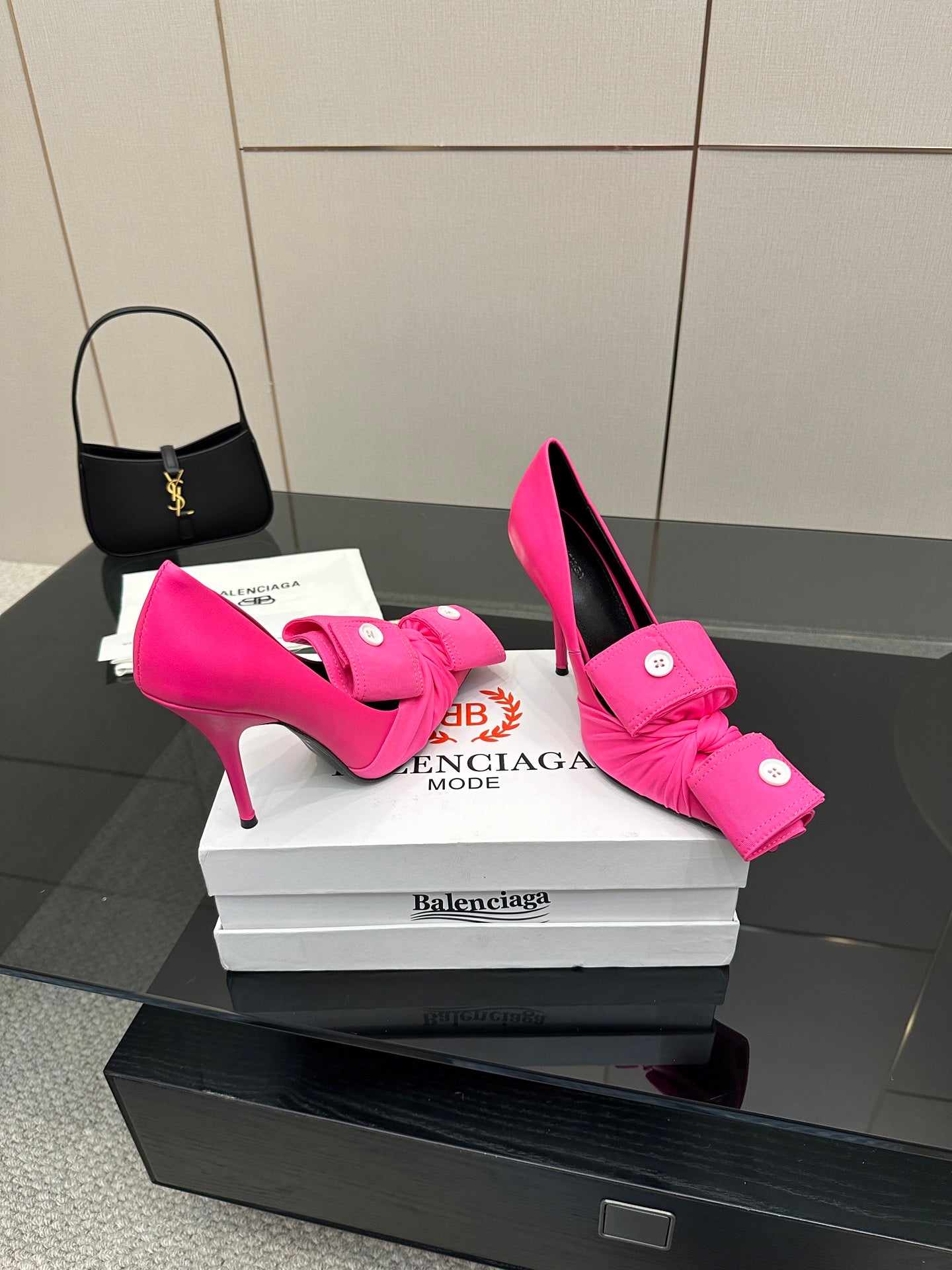 Pink high-heel pumps with bow-tie straps and round button hardware