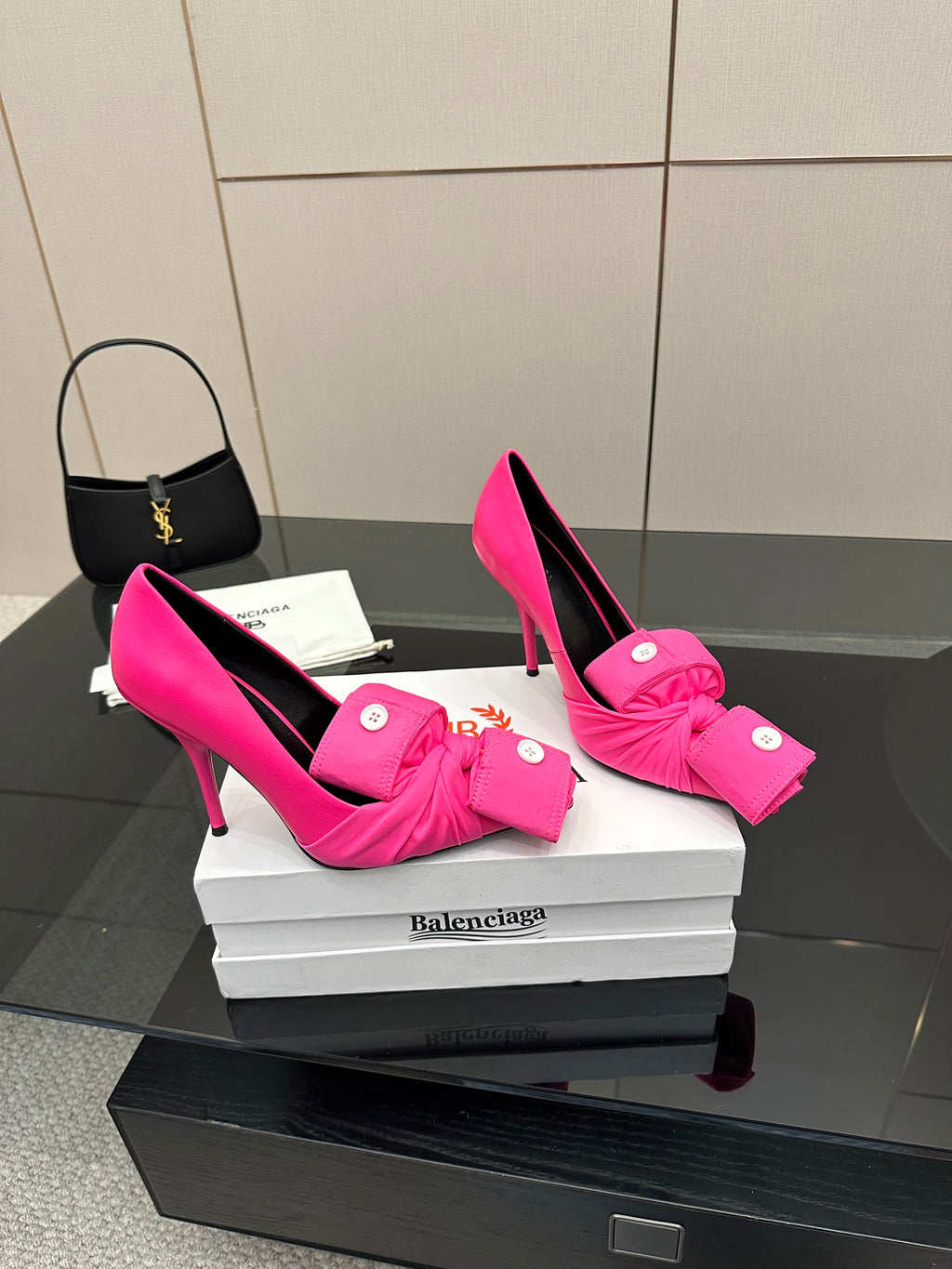 Pink pointed-toe high heels with front bow-tie and button accents