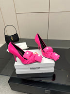 Pink pointed-toe high heels with front bow-tie and button accents