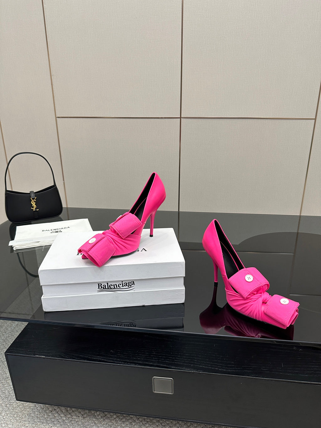 Pink pointed-toe stiletto heels with front bow-tie strap and button accents