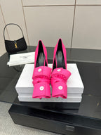 Pink high-heel shoes with knotted bow detailing and round button accents